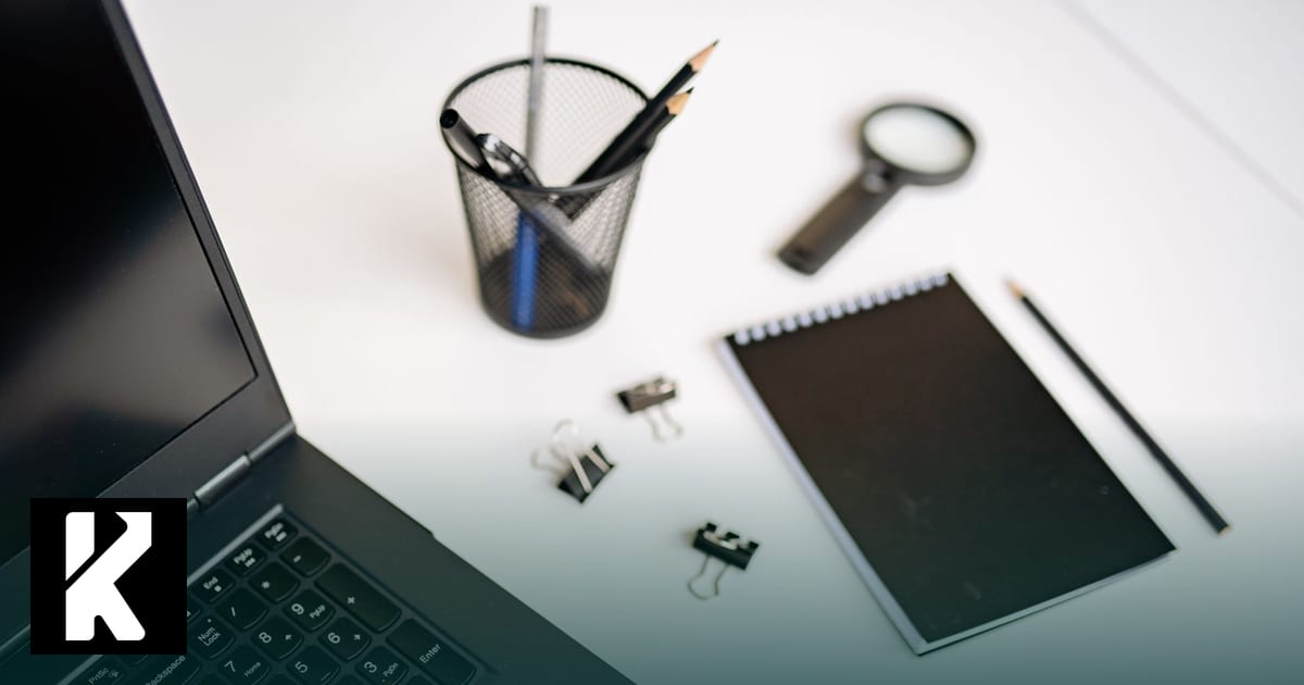 Bureau avec ordinateur portable, loupe, carnet et crayons — faire son diagnostic IA générative en TPE/PME