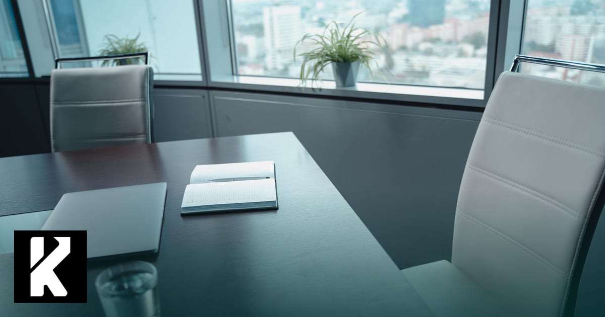 Carnet ouvert et ordinateur portable sur une table de salle de réunion — rédiger une charte IA générative en TPE/PME