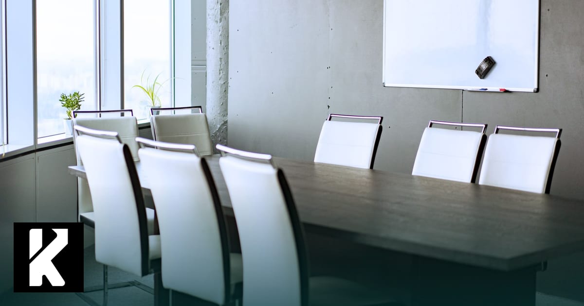 Salle de réunion vide avec grande table, chaises blanches et tableau blanc, prête pour la formation à la facturation électronique de l’équipe d’un cabinet comptable